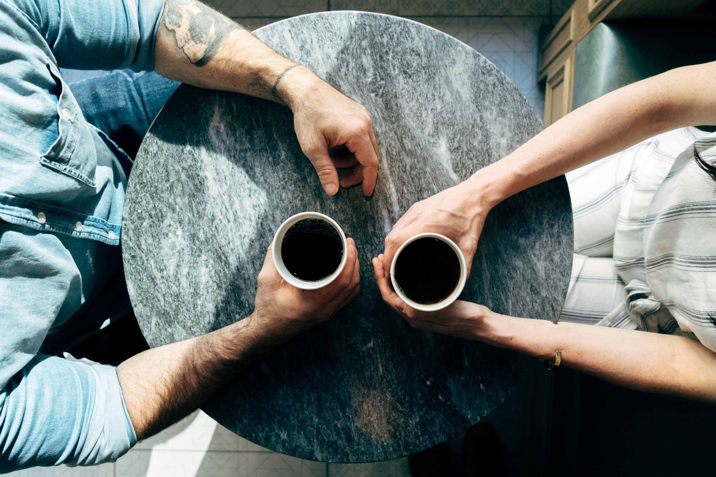 Two people talking over coffee at a small table