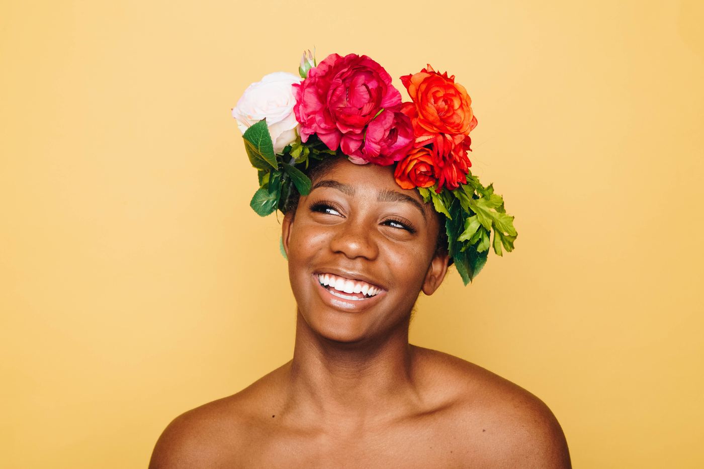 A smiling woman wearing a crown of flowers