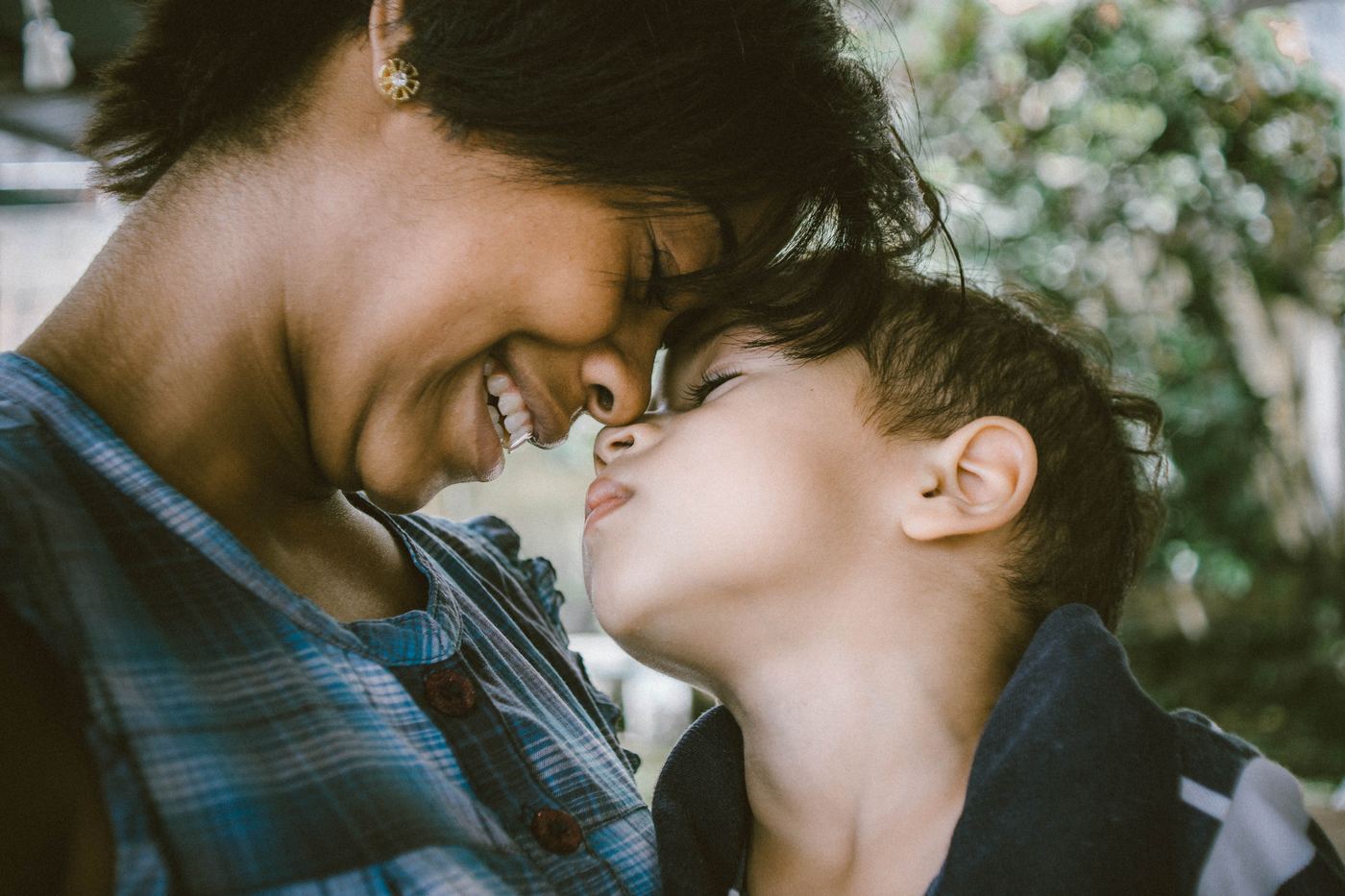 A mother and her son touching foreheads and smiling