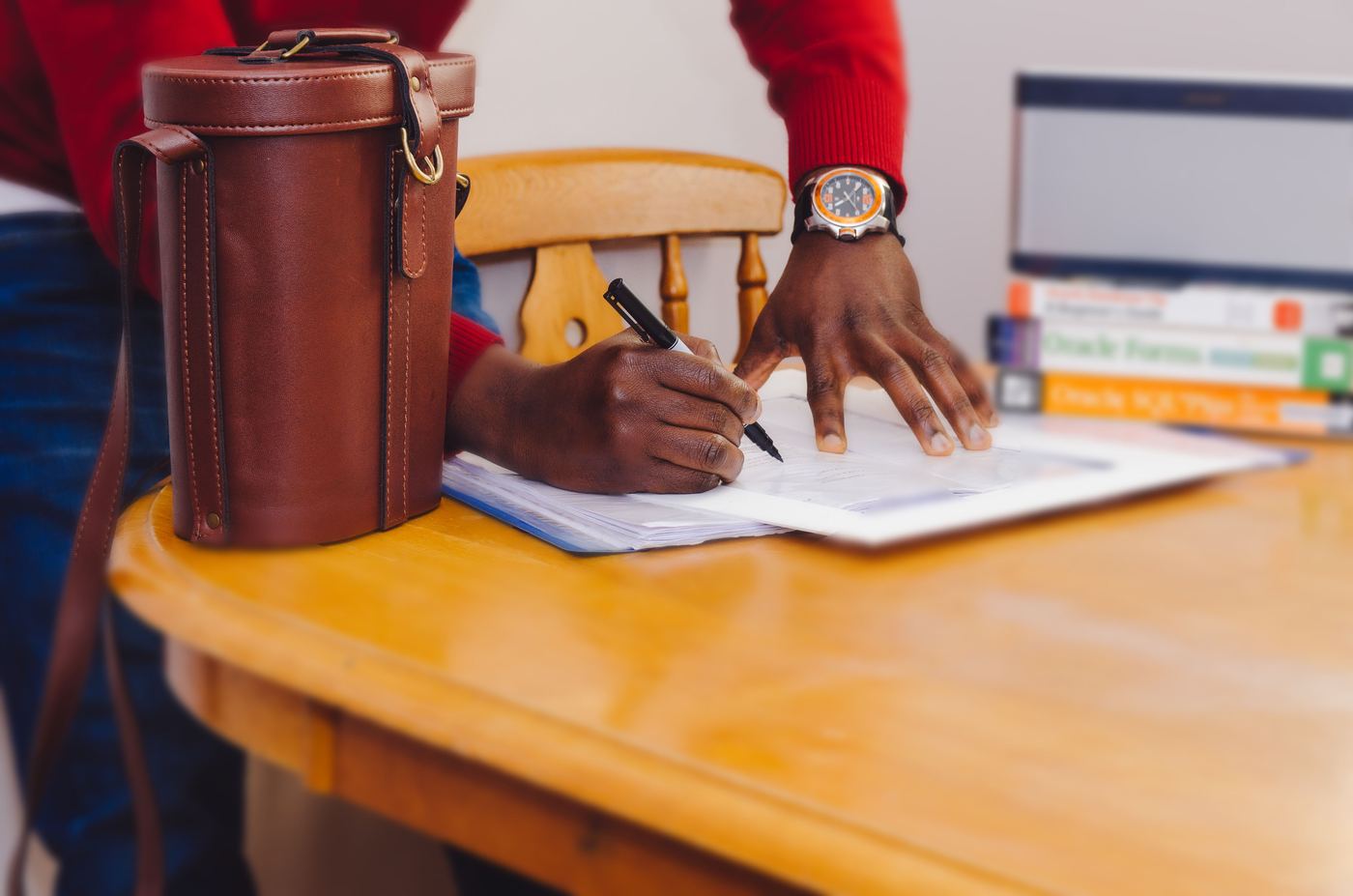 A man signing paperwork at a desk